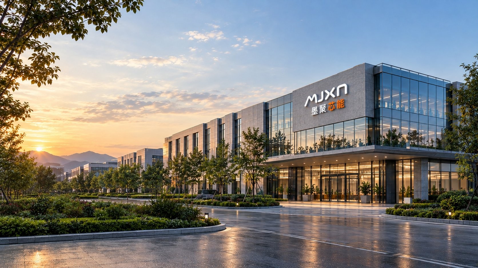 墨聚芯能园区主入口：建筑立面上的 MJXN 品牌标识与玻璃幕墙办公楼，落日映着远山，行道树与铺装广场